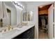 Elegant bathroom featuring dual sinks, black cabinetry with gold hardware, and a mirrored vanity at 3322 Dragon Fly St, North Las Vegas, NV 89032