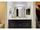 Stylish bathroom featuring double sinks, modern fixtures, arched mirrors, and a cabinet at 3322 Dragon Fly St, North Las Vegas, NV 89032