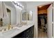 Well-lit bathroom with double sinks, arched mirrors, granite countertops, and storage at 3322 Dragon Fly St, North Las Vegas, NV 89032