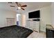 Bedroom with light wood floors, ceiling fan, dresser with television, and ensuite bathroom access at 3322 Dragon Fly St, North Las Vegas, NV 89032