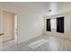Neutral bedroom with an open doorway, bright natural light, and stylish gray wood floors at 3322 Dragon Fly St, North Las Vegas, NV 89032