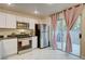 Bright kitchen featuring white cabinets, stainless steel appliances, and sliding glass doors to the patio at 3322 Dragon Fly St, North Las Vegas, NV 89032