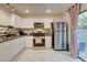 Modern kitchen boasting white cabinetry, stainless steel appliances, and a cozy dining nook with natural light at 3322 Dragon Fly St, North Las Vegas, NV 89032
