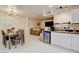 Contemporary kitchen and dining area featuring white cabinets, stainless steel appliances, and an open layout at 3322 Dragon Fly St, North Las Vegas, NV 89032