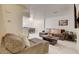 Open-concept living area with a dining space, featuring a sectional sofa and modern decor at 3322 Dragon Fly St, North Las Vegas, NV 89032