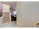 Modern staircase with light-colored steps, white risers, and a partial view of a furnished living room at 3322 Dragon Fly St, North Las Vegas, NV 89032
