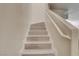 Close-up of staircase featuring light wood steps and a minimalist white handrail against a neutral wall at 3322 Dragon Fly St, North Las Vegas, NV 89032