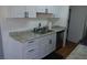 View of the kitchen sink and stainless steel dishwasher, complemented by white cabinetry at 3441 Villa Way, Las Vegas, NV 89120