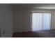 This living room features carpet, white paint, a wall with gray paint, white blinds and a sliding glass door to the exterior at 3441 Villa Way, Las Vegas, NV 89120