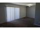 This living room features carpet, a wall with gray paint, white blinds and a sliding glass door to the exterior at 3441 Villa Way, Las Vegas, NV 89120