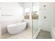 Bathroom with modern tub, glass-enclosed shower with seat, and tiled floors at 362 Tigullio Ave, Henderson, NV 89011