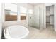 Bright bathroom with a modern tub, glass-enclosed shower, and tiled walls at 362 Tigullio Ave, Henderson, NV 89011