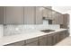 Modern kitchen featuring neutral countertops, cabinets, stainless appliances, and stylish backsplash at 362 Tigullio Ave, Henderson, NV 89011