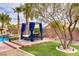 Beautiful backyard featuring a daybed, pool, palm trees, and mature trees creating an inviting desert oasis at 4624 Leon De Oro Dr, Las Vegas, NV 89129