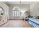 Bright bedroom with arched window, shutters, wood-look floors, and a comfortable sitting area at 4624 Leon De Oro Dr, Las Vegas, NV 89129
