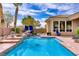 Beautiful swimming pool and spa with rock features, desert landscaping, and shaded lounge area, perfect for relaxation at 4624 Leon De Oro Dr, Las Vegas, NV 89129
