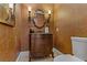 Charming powder room featuring a vintage vanity with dark wood finish, decorative mirror, and wall sconces at 4624 Leon De Oro Dr, Las Vegas, NV 89129