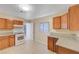 Cozy kitchen with wood cabinets, white appliances, and tile flooring at 520 Prince Alan Ct, Las Vegas, NV 89110