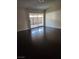 Bright living room featuring dark hardwood floors and sliding glass doors leading to an outdoor patio at 520 Prince Alan Ct, Las Vegas, NV 89110