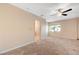 Carpeted main bedroom with ceiling fan, ensuite bath, and natural light from window at 520 Prince Alan Ct, Las Vegas, NV 89110
