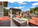 Beautiful backyard featuring an outdoor fire pit, grill, and comfortable seating surrounded by lush landscaping at 5742 Shadow Bend Dr, Las Vegas, NV 89135