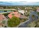 Panoramic view of a luxurious estate home with lush landscaping, golf course, and mountain views at 60 Innisbrook Ave, Las Vegas, NV 89113