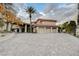 A stunning home with a three-car garage, a circular driveway, and lush landscaping at 60 Innisbrook Ave, Las Vegas, NV 89113