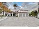 A stunning home with a three-car garage, a circular driveway, and lush landscaping at 60 Innisbrook Ave, Las Vegas, NV 89113