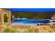 An elegant pool featuring a luxurious cabana, waterfall feature, lush landscaping, and tiled patio at 60 Innisbrook Ave, Las Vegas, NV 89113