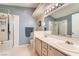 Bright bathroom with double sink vanity, framed mirror, and glass enclosed shower at 605 Devonhall St # 201, Las Vegas, NV 89145