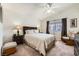Bedroom with neutral walls, carpet, ceiling fan and comfortable accent chair with foot stool at 605 Devonhall St # 201, Las Vegas, NV 89145