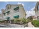 Exterior view of building featuring desert landscaping, stucco facade, and green awnings at 605 Devonhall St # 201, Las Vegas, NV 89145