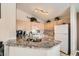 Bright kitchen showcasing light wood cabinets, granite countertops, and modern appliances at 605 Devonhall St # 201, Las Vegas, NV 89145