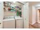 Laundry room with standard washer and dryer, shelves stocked with supplies at 605 Devonhall St # 201, Las Vegas, NV 89145