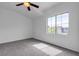 A sun-filled bedroom featuring a ceiling fan and a window with a view of the neighborhood at 6325 Orions Tool St, North Las Vegas, NV 89031