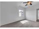A sunny bedroom with carpet, a ceiling fan, and a window with a view of the neighborhood at 6325 Orions Tool St, North Las Vegas, NV 89031