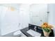 Bright bathroom with white tile, dark countertop, and modern fixtures at 669 Elliot Peak Ave, Las Vegas, NV 89183