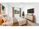 Comfortable bedroom with a TV, decorative plants, and natural light from the window at 669 Elliot Peak Ave, Las Vegas, NV 89183