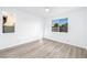 Bright bedroom featuring wood-look flooring, neutral walls, and large windows at 669 Elliot Peak Ave, Las Vegas, NV 89183
