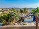 Charming single-story home with a well-manicured front yard, two-car garage, desert landscaping, and shade trees at 669 Elliot Peak Ave, Las Vegas, NV 89183
