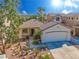 Charming single-story home with a well-manicured front yard, two-car garage and desert landscaping at 669 Elliot Peak Ave, Las Vegas, NV 89183