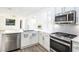 Modern kitchen features stainless appliances, quartz countertop, and adjacent living area at 669 Elliot Peak Ave, Las Vegas, NV 89183