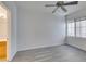 This bedroom has a ceiling fan and a bright window with modern gray wood flooring at 7151 S Durango Dr # 211, Las Vegas, NV 89113