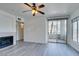 Bright open living room featuring wood-look floors, fireplace, ceiling fan and sliding glass door to balcony at 7151 S Durango Dr # 211, Las Vegas, NV 89113