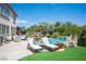 Resort style pool, waterfall, and lounge chairs with an outdoor seating area surrounded by lush landscaping at 7538 Mustang St, Las Vegas, NV 89131