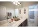 Bright bathroom with double sinks, decor, and a view of a shower-tub combo with tiled walls at 7538 Mustang St, Las Vegas, NV 89131