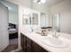 Bathroom features dual sinks, dark wood cabinets, decorative jars, and access to a bedroom at 7538 Mustang St, Las Vegas, NV 89131