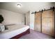 Well-lit bedroom featuring stylish sliding barn doors, neutral paint, plush carpet, and relaxing decor at 7538 Mustang St, Las Vegas, NV 89131