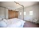 Spacious bedroom with a hanging chair and rustic sliding closet doors at 7538 Mustang St, Las Vegas, NV 89131