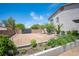 A well-maintained garden featuring raised beds, gravel pathways, and mature trees, ideal for gardening enthusiasts at 7538 Mustang St, Las Vegas, NV 89131